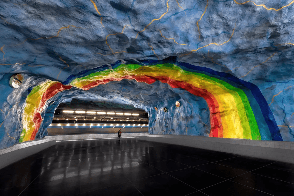 A rainbow arcs over a girl on the platform of Stadion station. Image courtesy of The Guardian.